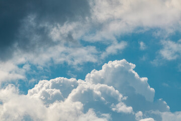 High layered white epic clouds on blue sunny sky. Heavenly cloudscape background