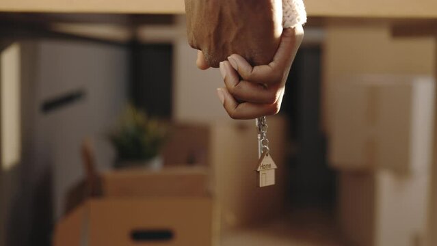 Happy african american young family bought new house. Young married couple wife and husband hold keys having fun laugh into modern home. New home and moving concept.