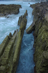 long exposure of the sea churning between rock strata
