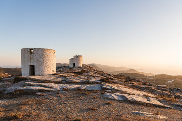 Golden hour view of the traditional windmills of Chora, on Amorgos island in Greece. - obrazy, fototapety, plakaty