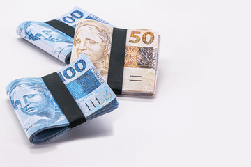 Brazilian real notes, 100 and 50 reais, ten thousand reais, millionaire grand prize, lottery or big luck. White background in copyspace
