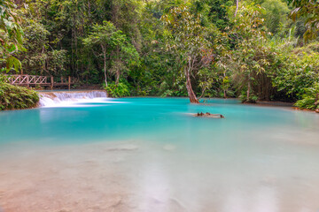 Magical turquoise blue colours of Kuang Si waterfalls Luang Prabang Laos. these waterfalls in the Mountains of Luang Prabang Laos flow all year round in the natural national park rainforest 