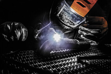 Welder in a mask welds with argon.