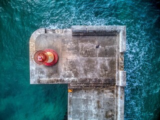 Drone shot from above of Kalk Bay Breakwater Head Lighthouse, near Cape Town, South Africa