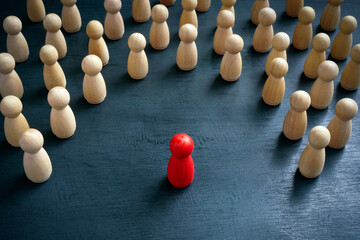 Discrimination and inclusion concept. The wooden figurines surrounded the red one. - obrazy, fototapety, plakaty