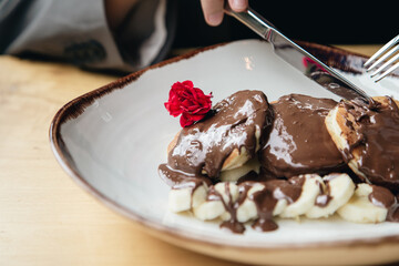 Close-up, delicious pancakes with chocolate and banana for breakfast.