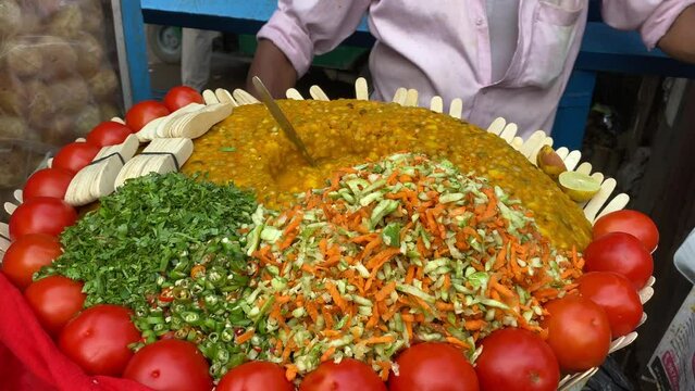 man cooking the famous Ghugni chat or chickpea curry in the streets of Kolkata for sale. India. No face video