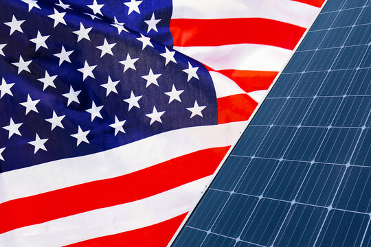 Solar panels against flag US background. Solar battery generates a pure electricity. Concept of sustainable resources and renewable energy in USA