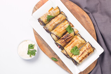Baked grilled eggplant rolls with cottage cheese, tomatoes and sour cream. Georgian cuisine. 