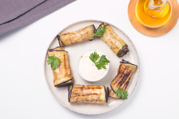 Baked grilled eggplant rolls with cottage cheese, tomatoes and sour cream. Georgian cuisine. 