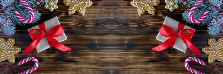 Christmas banner with gingerbread and gift box on the wooden background.Top view.Copy space.