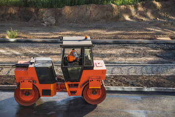 Road roller rolls out asphalt. Road construction concept