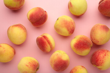 Fresh ripe peaches on pink background, top view.