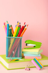 Fototapeta premium School accessories with books on pink background. Back to school concept. Vertical photo