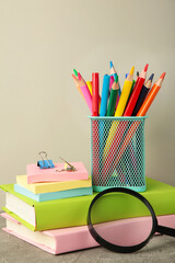 Fototapeta premium School accessories with books on grey background. Back to school concept. Vertical photo