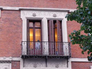 Fototapeta na wymiar Close up on classical balcony with double doors and shutters downtown Madrid in Chueca district, Spain