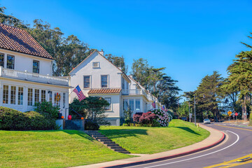 Suburban neighborhood with sloped lawn near the curved street in San Francisco, CA