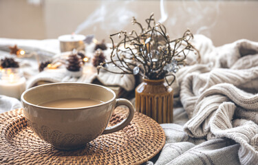 Cozy autumn composition with a big cup of coffee in bed.