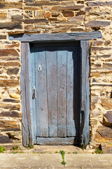 Old and ancient wooden door in rural stone construction