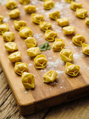 Close-up. Appetizing homemade dumplings stuffed with minced meat on a wooden cutting board. Preparation of dishes from dough and meat. Home and restaurant cuisine. Family traditions.