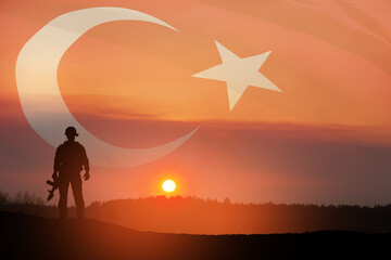 Fototapeta na wymiar Silhouette of soldier on a background of Turkey flag and the sunset or the sunrise. Concept of crisis of war and conflicts between nations. Greeting card for Turkish Armed Forces Day, Victory Day.