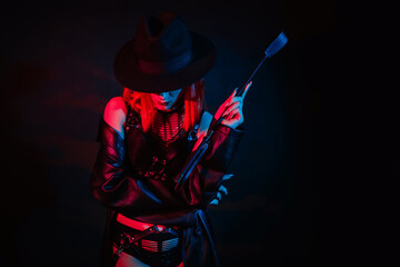 sexy girl in beautiful underwear in a hat holds a leather whip flogger for BDSM sex with submission...