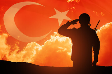 Silhouette of soldier on a background of Turkey flag and the sunset or the sunrise. Concept of crisis of war and conflicts between nations. Greeting card for Turkish Armed Forces Day, Victory Day.