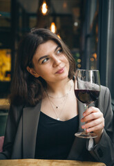 Attractive young woman with a glass of wine in a restaurant.