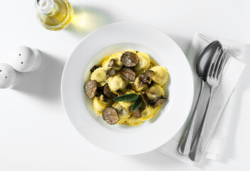 Italian ravioli with butter, parmesan cheese and truffle on the white table