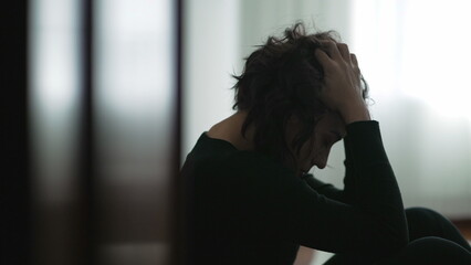 Blurry shot of person in crisis sitting on floor. Out of focus take of young woman during hard times