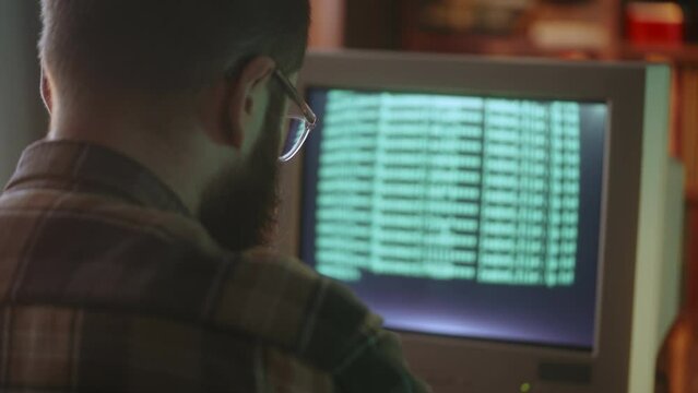 Male geek uploading virus on retro desktop computer, hacking office software