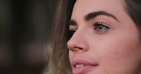 Young woman opening eyes. Close-up of girl face with green eyes looking at horizon thinking about life in meditative contemplation