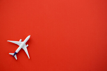 Flat lay design of travel concept with plane on red background