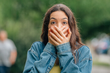 girl on the street scared or surprised with her hands on her face