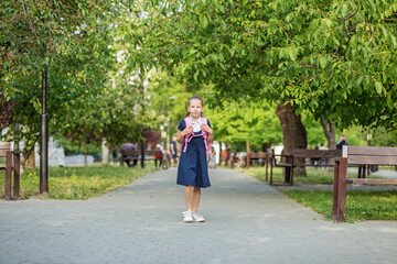 Fototapeta na wymiar Beautiful child girl with backpack goes to school. Concept of back to school, education