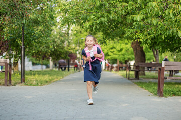 Fototapeta premium Beautiful schoolgirl runs with backpack to school. Concept back to school, education