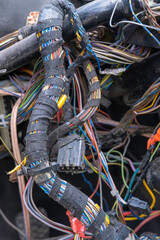 A bundle of electrical wires or cables is strongly mixed up with each other. Remnants of wires of different colors. Old cables connected to each other in the nodes of the car