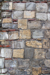 Full frame texture background of an old medieval European gray color European stone wall