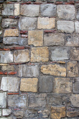 Full frame texture background of an old medieval European gray color European stone wall