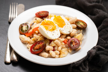 Salad with Fried cod fish and white beans on the plate.