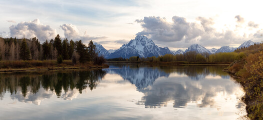 River surrounded by Trees and Mountains in American Landscape. Snake River, Oxbow Bend. Spring Season. Grand Teton National Park. Wyoming, United States. Nature Background Panorama. Sunset