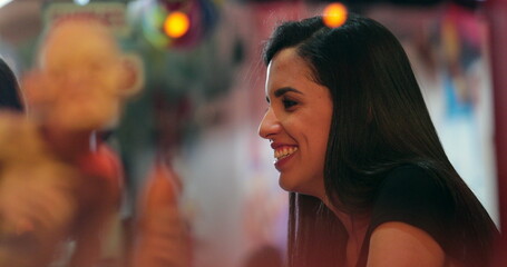 Night scene of Candid casual young women talking to person off-camera seen through restaurant window