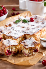 Sponge cake with cherries on a board on the table. Homemade pie