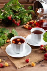 Raspberry tea with natural berries on wooden table, vitamin tea for weight loss