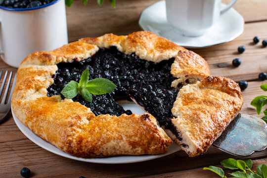 A piece of homemade galette with blueberries in a white plate on a culinary background. Delicious sweet pastries