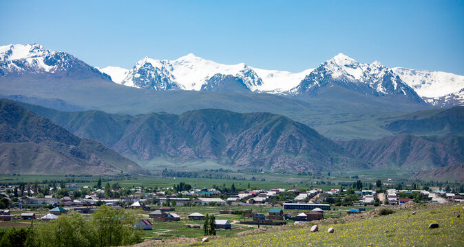 The village of Kyzyl Tuu with the Tian Shan Mountains in the background in Kyrgyzstan.