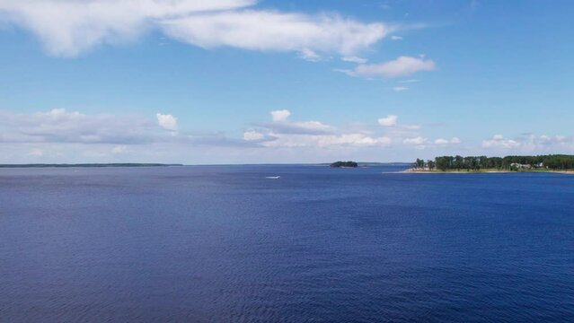 A drone shot of calm beautiful Sam Rayburn Lake in Texas with a speed boat in distance.