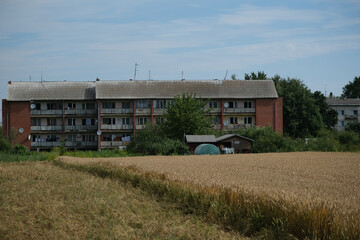 Soviet building in Latvia countryside. The old panel house near wheat field