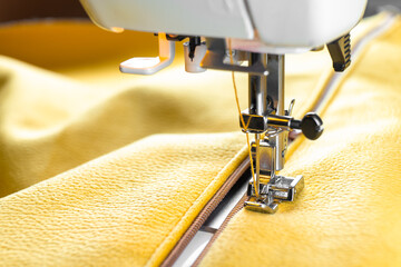 Modern sewing machine special presser foot and zipper with yellow fabric. Sewing process clothes,...