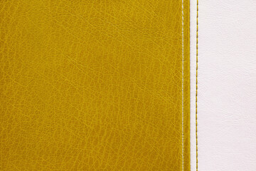Natural, artificial yellow and white leather texture background with vertical decorative seam. Material for sport items, clothes, furnitre and interior design. ecological friendly leatherette.